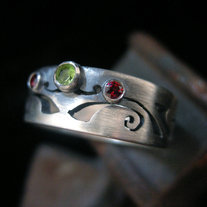 Silver pierced band ring 8, with peridot and garnet.  Hand cut.
